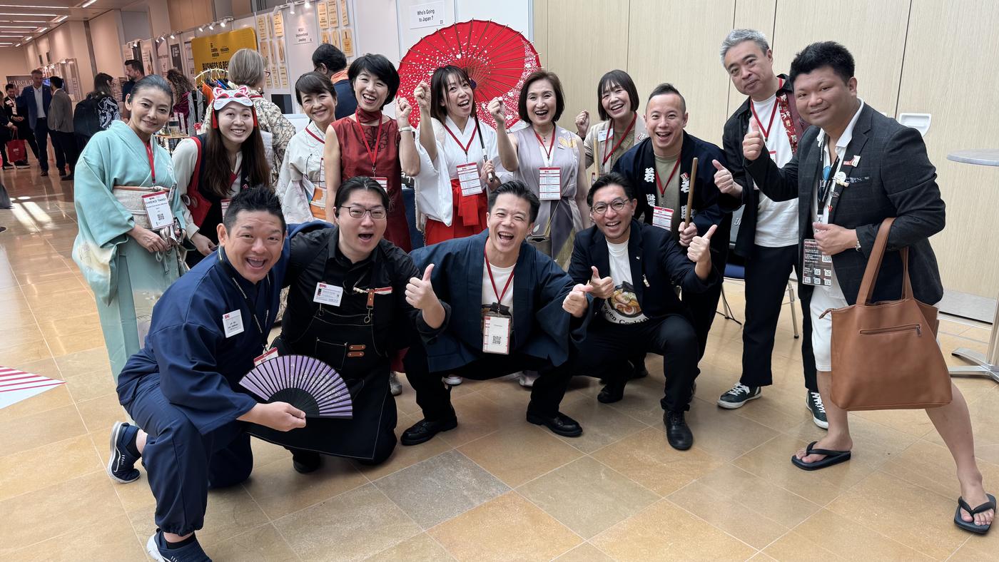 モナコ大会の共同ブース「Who's Going to Japan?」の前で、和装のメンバーが並んだ集合写真